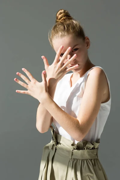 Девушка Позирует Студии Ладони Перед Лицом Пальцы Широко Расставлены Выглядит — стоковое фото
