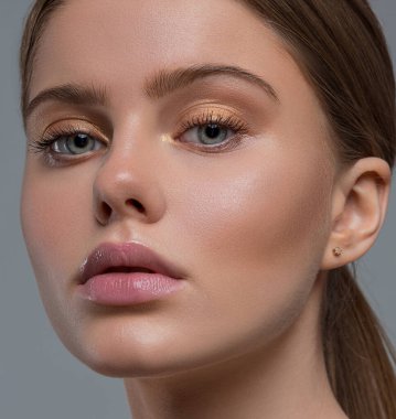 Bir kadının yüzüne yakın çekim. Güzellik. Temiz ve sağlıklı cilt. Altın göz farı. Kadın portresi.