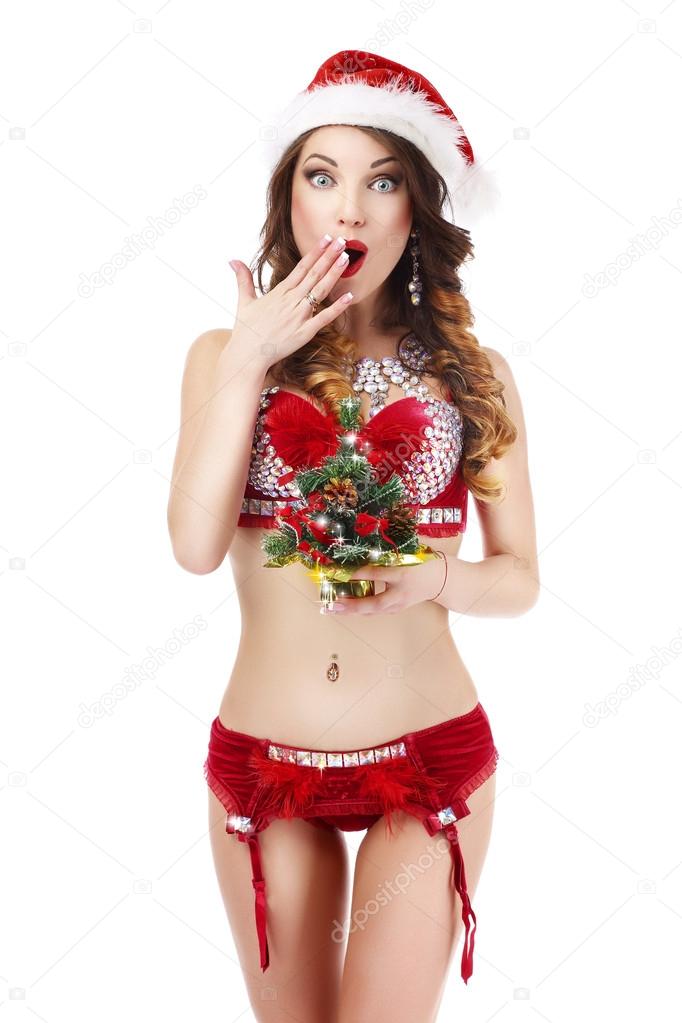 Xmas. Astonished Glamorous Woman in Santa Claus' Costume with Christmas Gift