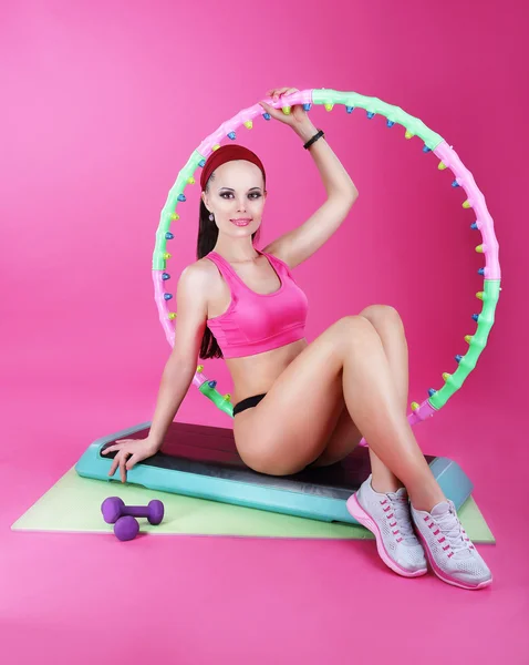 Здоровый образ жизни. Спортивная женщина сидит на коврике с оборудованием для фитнеса — стоковое фото