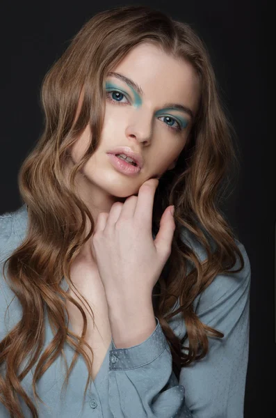 Fantasie. jonge brunette met ongewone blauw oog make-up — Stockfoto