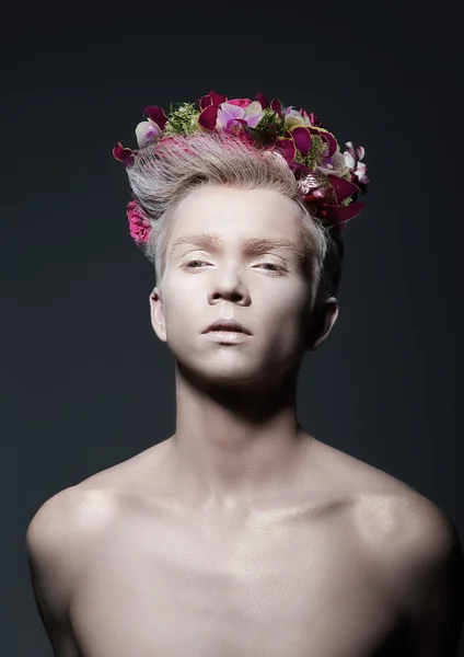 Schönheit. Junger Mann mit Blumenkranz über Grau — Stockfoto