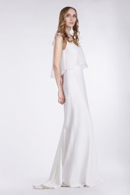 Kadınlık. Beyaz elbiseli duran sevimli genç kadın