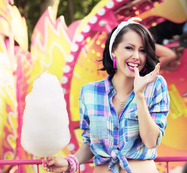 Sonrisa dentada. Mujer joven con caramelo de algodón en el parque de atracciones —  Fotos de Stock