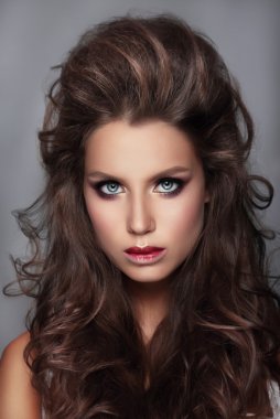 İle kadın parlak makyaj ve kıvırcık saçlar.