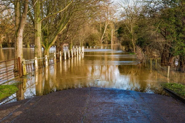 Overstroomd landweg door de rivier in de maand maart — Stockfoto