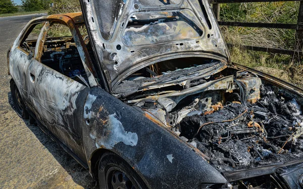 Un coche abandonado incendiado y quemado. — Foto de Stock