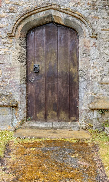 Alte unbenutzte Holztür in einer Steinmauer — Stockfoto