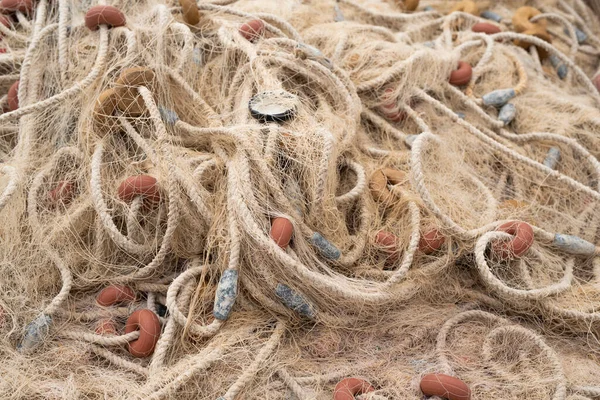 Entangled metal cap of bottle in fishing nets. background of different trawlers and floats. Close up. Still life.