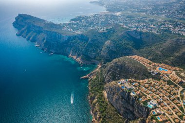 İspanya 'nın Alicante şehrinde kayalıklarda bulunan renkli binaları, villaları ve havuzları olan Montecala köyünün en iyi hava manzarası. Sıcak yaz güneşli gün.
