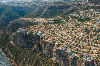 İspanya 'nın Alicante şehrinde kayalıklarda bulunan renkli binaları, villaları ve havuzları olan Montecala köyünün en iyi hava manzarası. Sıcak yaz güneşli gün.