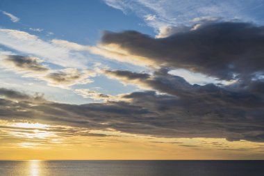 Torrevieja, Alicante, İspanya 'nın kayalık sahil kıyısında, güneşin erken doğuşu ve destansı bulutlu bir gökyüzü. Akdeniz 2019.