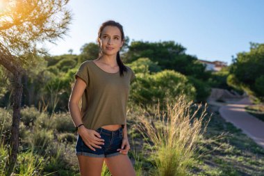 Parktaki güzel esmer kız turist. Spor kıyafetleri içinde şık bir kız..