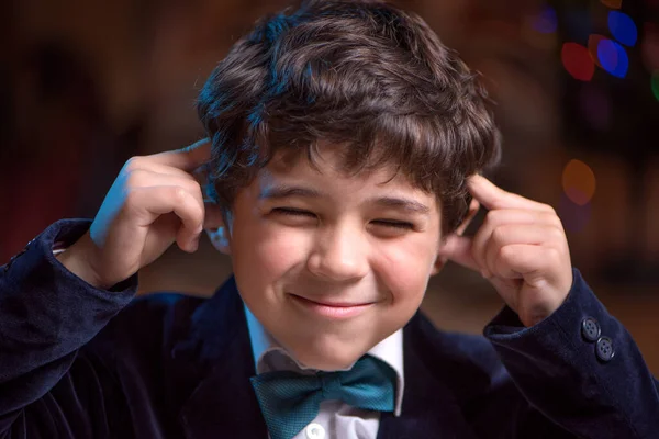 Pequeno Garoto Tapando Ouvidos Fechando Olhos Mas Sorrindo — Fotografia de Stock