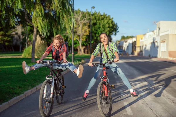 Дві Красиві Молоді Кавказькі Дівчата Розважаються Велосипедах Вздовж Вулиці Найкращі Ліцензійні Стокові Фото