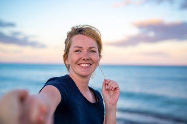 Beni takip edin - mutlu genç kadın erkeğin elini tutuyor - gün batımında el ele yürüyor - tasasız modern hayat kavramı.