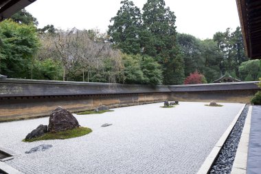 Kyoto 'daki Ryoanji Tapınağı' ndaki Zen Rock Garden 'da. Japonya. Bir bahçede beyaz çakıl üzerinde on beş taş var.. 