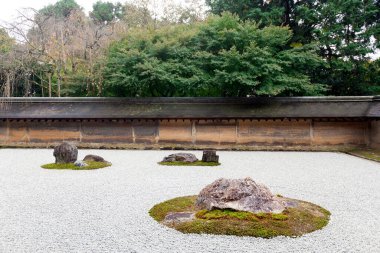 Kyoto 'daki Ryoanji Tapınağı' ndaki Zen Rock Garden 'da. Japonya. Bir bahçede beyaz çakıl üzerinde on beş taş var.. 