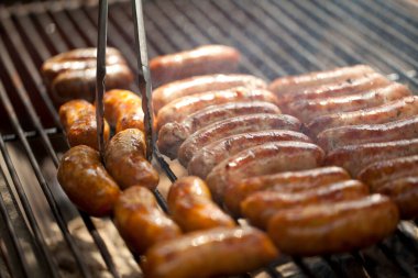 Bahçede ya da arka bahçede kömürlü barbekü ızgarası. Bir sürü dumanlı sosis..