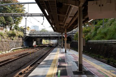 İş adamı Japonya, Tokyo 'daki Iidabashi istasyonunda JR hatlarını bekliyor..