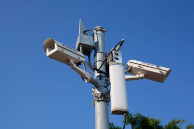 Mavi gökyüzünün önündeki güvenlik kameraları