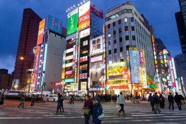Tokyo, Japonya 'da gece vakti Shinjuku bölgesindeki renkli reklam panosu ışıklarıyla sokak ve şehir manzarası.