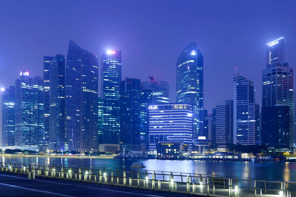 View of many modern office buildings at night in Singapore, Singapore. Singapore is home to many international businesses headquarters.