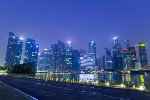 View of many modern office buildings at night in Singapore, Singapore. Singapore is home to many international businesses headquarters.