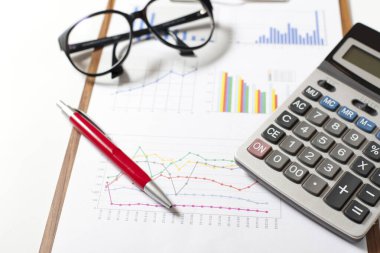 Finans ve iş konsepti. Masadaki mali grafiklerde hesap makinesi var. Muhasebe bütçe kredileri veya piyasa analizi.