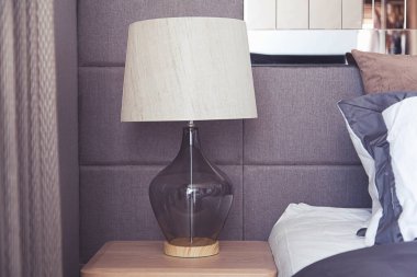 Çağdaş iç tasarımı olan modern yatak odası, rahat yatağın üzerinde lamba ışığı.