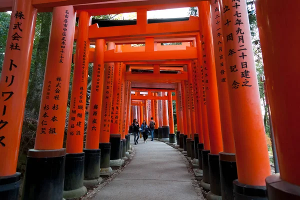 人々は京都の伏見稲荷神社の有名な赤い鳥居を歩く — ストック写真