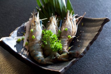 Tabakta üç çiğ karides, pişmeye hazır taze Kara Kaplan Karidesi..