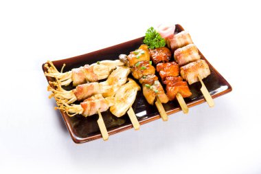 Çeşitli türde ızgara kushiyaki ya da beyaz arka planda et şişleri. Japon usulü İzakaya restoranında şiş yemek..