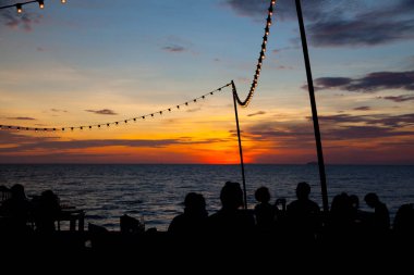 İpte ampul, kumsalda parti dekorasyonu, güzel günbatımı gökyüzü..