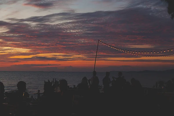 light bulb on a string, party decoration at the beach with beautiful sunset sky.