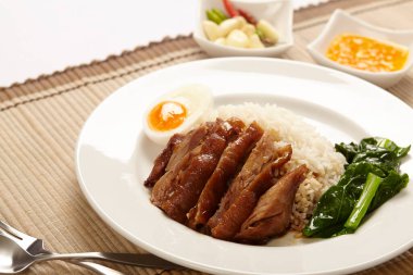 Beyaz tabakta pirinçli domuz budu..