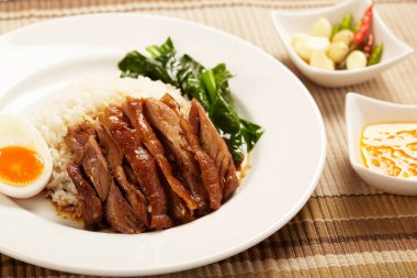 Beyaz tabakta pirinçli domuz budu..