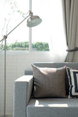 Gri kanepeli ve sarı yastıklı şık bir oturma odası. İç tasarım gri ve sarı renklerde..