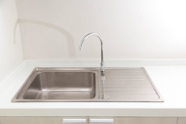 Bir mutfak tezgahı ve pencerenin yanındaki modern evde küçük bir mutfak lavabosu..