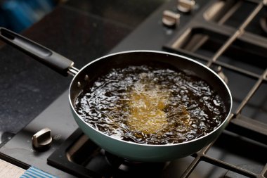 Deep fried tofu in a pan with the boiling oil. Cooking in kitchen.