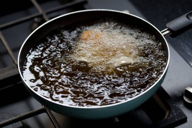 Deep fried tofu in a pan with the boiling oil. Cooking in kitchen.