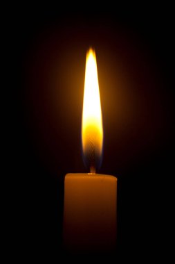 Siyah bir arkaplanda yanan bir mum ışığı.