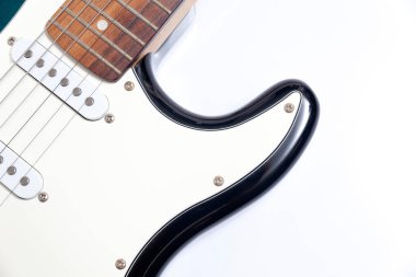 Humbucker pikaplı siyah elektro gitar, yakın çekim. Beyaz duvar arkaplanındaki müzikal enstrüman şekli.