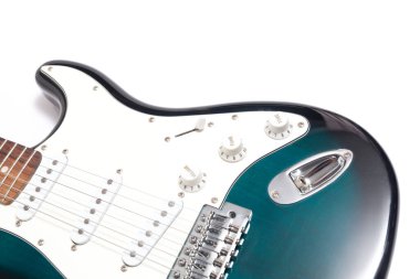 Humbucker pikaplı siyah elektro gitar, yakın çekim. Beyaz duvar arkaplanındaki müzikal enstrüman şekli.