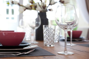 Modern yemek odasındaki yemek masasının üzerindeki cam ve tabağı kapatın. İç tasarım kavramı.