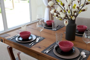 Modern yemek odasındaki yemek masasının üzerindeki cam ve tabağı kapatın. İç tasarım kavramı.