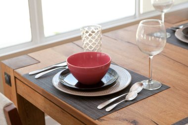 Modern yemek odasındaki yemek masasının üzerindeki cam ve tabağı kapatın. İç tasarım kavramı.