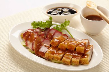 Doğu usulü domuz eti ya da beyaz arka planda beyaz tabakta soslu Char Siew..