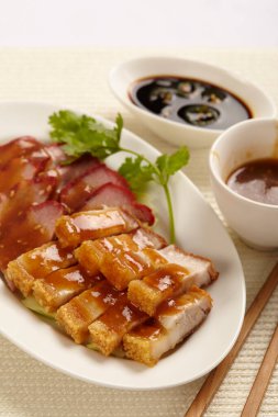 Doğu usulü domuz eti ya da beyaz arka planda beyaz tabakta soslu Char Siew..