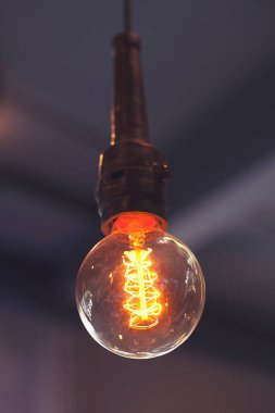 Karanlık odada sarkan parlak ampullerin yakın çekimi. Düz telli dekoratif antika Edison ampulleri. Küçültülebilir, ılık beyaz, E27